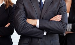 People in suits with arms crossed